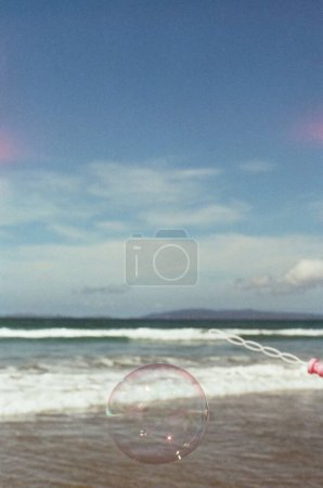 Téléchargez les photos : Une verticale de belles bulles de savon transparentes avec les vagues de mer mousseuses dans le fond flou - en image libre de droit