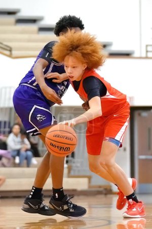 Photo for A young white basketball player in orange jersey dribbling the ball - Royalty Free Image