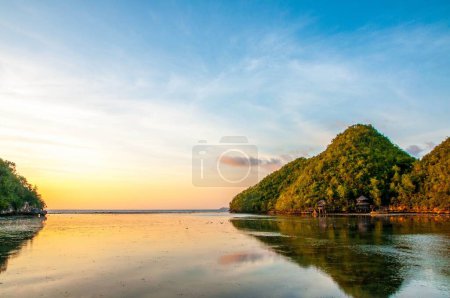 Téléchargez les photos : Un beau paysage d'un lac et les forêts sur la colline pendant le coucher du soleil - en image libre de droit