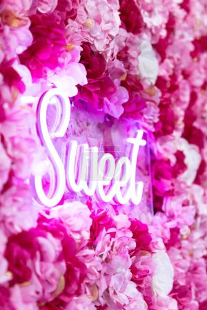 Téléchargez les photos : Le texte néon "doux" avec décoration de fleurs sur le mur - en image libre de droit