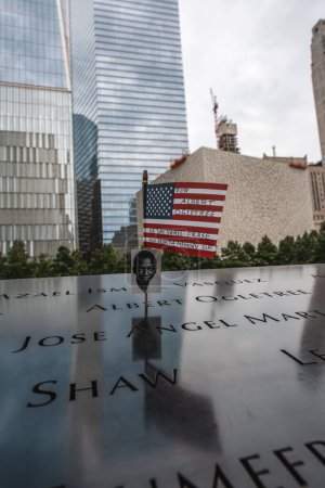 Téléchargez les photos : Un plan vertical du drapeau américain avec une photo d'Albert Ogletree au mémorial du World Trade Center. - en image libre de droit