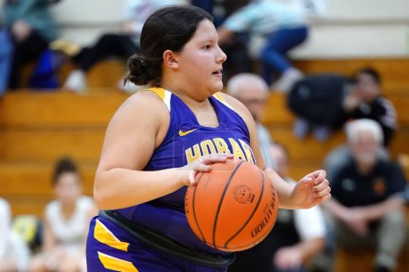 Téléchargez les photos : Une fille jouant au basket-ball pendant le tournoi de filles automne lycée en Australie - en image libre de droit