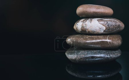 Photo for A pile of pebbles on a dark glowing surface - Royalty Free Image