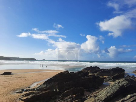 Foto de Una hermosa toma de rocas en una playa bajo un cielo azul nublado - Imagen libre de derechos