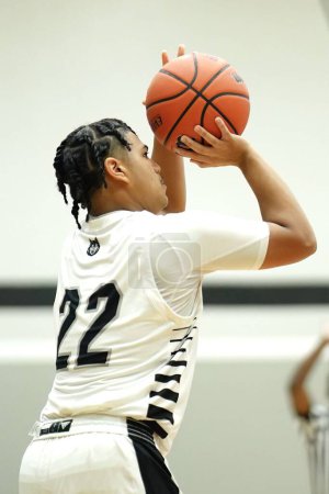 Téléchargez les photos : Plan vertical d'un jeune joueur masculin sur le terrain lors d'un match de basket-ball du lycée de Merrillville - en image libre de droit