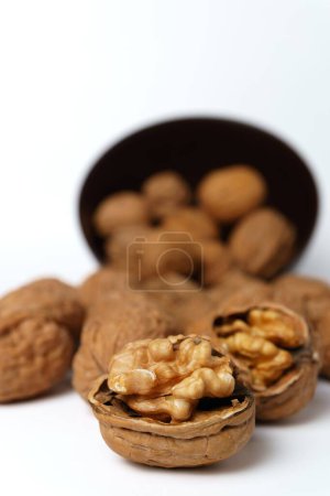 Foto de Walnuts in a brown bowl isolated on a white background - Imagen libre de derechos
