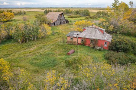 Téléchargez les photos : Une antenne d'une ancienne ferme en bois abandonnée avec le champ en arrière-plan dans les Prairies canadiennes - en image libre de droit