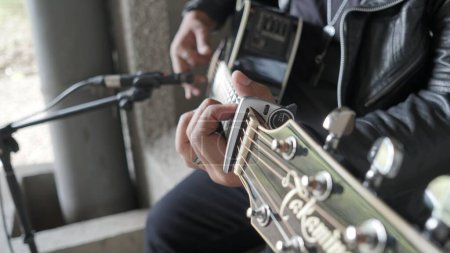 Téléchargez les photos : Gros plan d'un musicien masculin jouant de la guitare avec un microphone devant lui - en image libre de droit