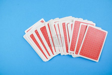 Photo for A pack of red cards on a blue background - the concept of gambling - Royalty Free Image