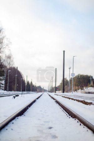 Foto de Una toma vertical a nivel del suelo de vías de tren cubiertas de nieve en un hermoso día de invierno - Imagen libre de derechos