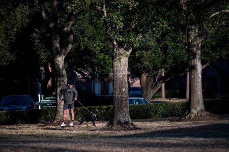 Téléchargez les photos : Houston, TX, États-Unis - 26 Décembre 2022 : Jeune homme skateboard avec son chien à Bay Point Park à Houston Texas. - en image libre de droit