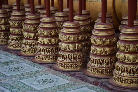 Photo for A close-up shot of buddhist prayer wheels in a row on a table - Royalty Free Image