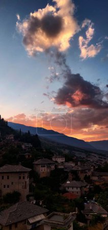 Téléchargez les photos : Un plan vertical du coucher de soleil sur les bâtiments avec des collines en arrière-plan - en image libre de droit