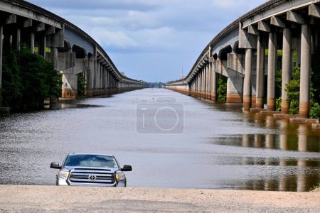 Foto de Un coche Toyota en una pendiente con el río entre dos puentes en el fondo en Henderson, EE.UU. - Imagen libre de derechos