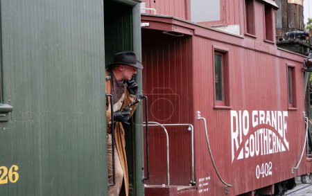 Foto de Un bandido del tren susurrando silencio a todo el mundo mientras pasan - Imagen libre de derechos