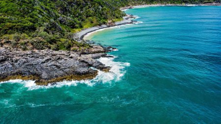 Téléchargez les photos : Une vue de drone des vagues d'eau de l'océan turquoise s'écrasant sur une île rocheuse - en image libre de droit
