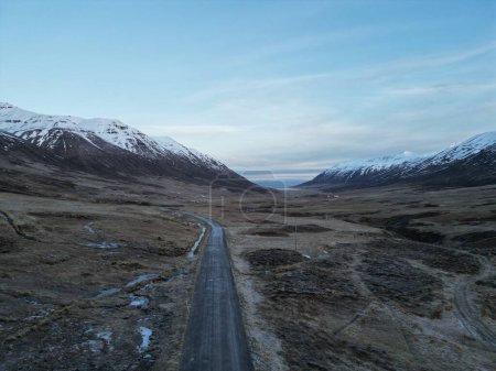 Photo for The empty country road in Olafsfjordur valley surrounded by mountains. Iceland. - Royalty Free Image