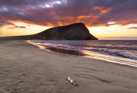 Foto de Una hermosa toma de un brillante cielo al atardecer sobre una orilla del mar con un acantilado en la isla de Tenerife - Imagen libre de derechos