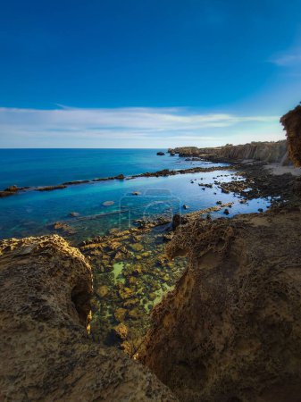 Photo for A vertical shot of the rocky coast of Albufeira, Sao Rafael, Portugal - Royalty Free Image