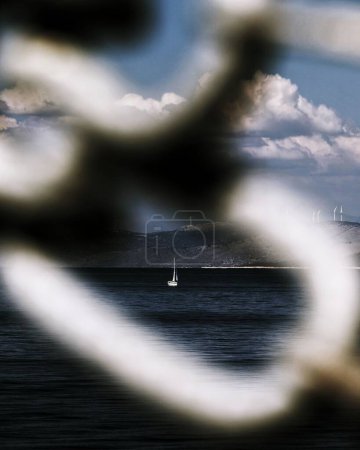 Téléchargez les photos : Une vue d'un voilier à travers le trou de clôture - en image libre de droit