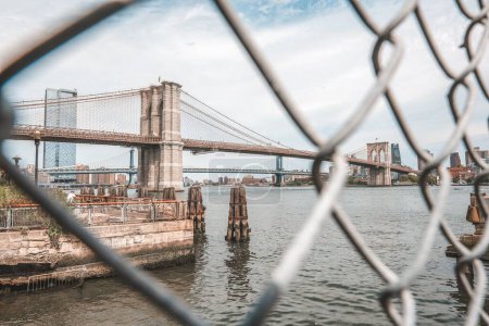Photo for The view of the Brooklyn Bridge through the metal fence. New York City, USA. - Royalty Free Image