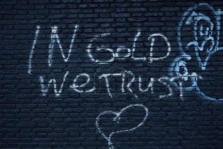 Téléchargez les photos : Le texte "En or nous faisons confiance" sur le mur - en image libre de droit