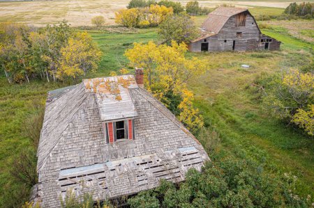 Photo for An aerial of an old abandoned wooden homestead with the field in the background in Canadian prairies - Royalty Free Image