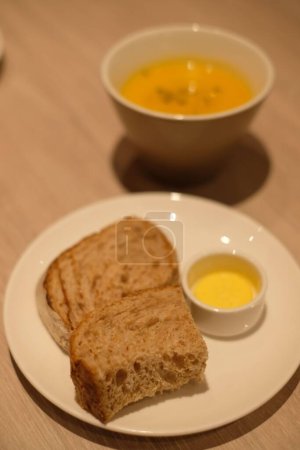 Foto de Una sopa de pan, mantequilla y calabaza sobre la mesa - Imagen libre de derechos