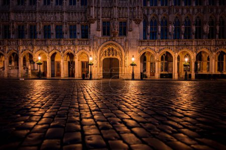 Photo for A cobblestone street in front of a building at night in Brussels Town Hall, Belgium - Royalty Free Image