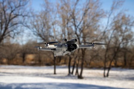Téléchargez les photos : Vue aérienne d'un drone volant et enregistrant des images par une journée ensoleillée et enneigée - en image libre de droit