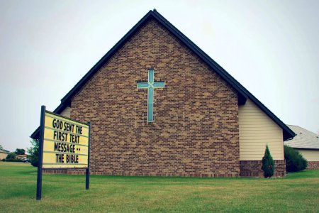 Téléchargez les photos : Une église luthérienne Messie dans l'herbe avec un fond de ciel sombre - en image libre de droit