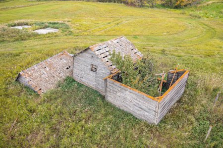 Foto de Una antena de una antigua granja de madera abandonada con el campo en el fondo en las praderas canadienses - Imagen libre de derechos