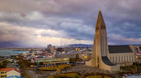 Foto de El Hallgrimskirkja rodeado de edificios en un día nublado y sombrío en Reikiavik, Islandia - Imagen libre de derechos
