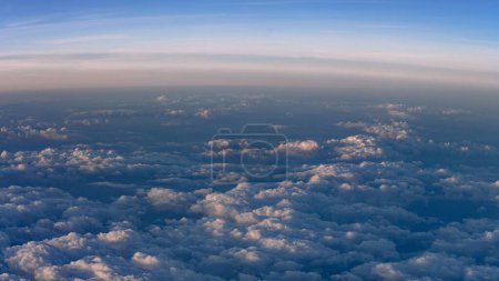 Foto de Vista desde el avión. El sol se pone y brilla una luz cálida en las nubes. - Imagen libre de derechos