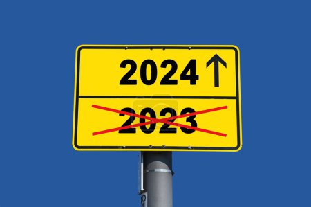 Téléchargez les photos : Panneau jaune avec lettrage noir. En dessous du mot 2023 rayé en rouge et au-dessus le mot 2024 avec une flèche. - en image libre de droit