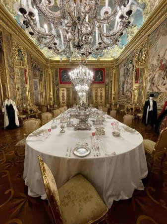 Photo for A vertical of a big table at the dining room in the Royal Palace of Turin with big chandeliers - Royalty Free Image