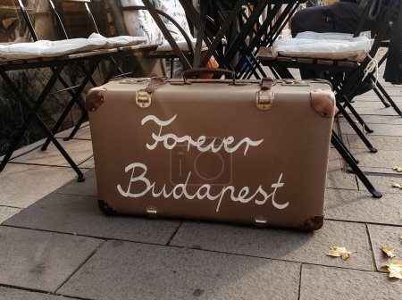 Photo for A closeup of a travel case with the text "Forever Budapest" on the terrace of a cafe - Royalty Free Image