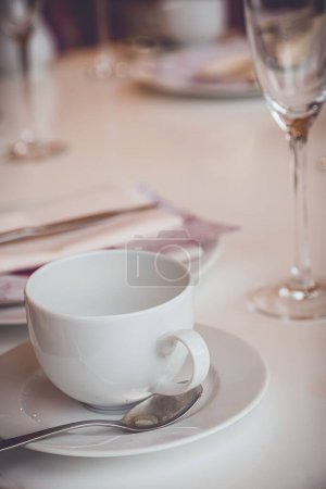 Foto de Un enfoque selectivo de una taza de té blanco vacía con cuchara en una mesa puesta para el té de la tarde Inglés - Imagen libre de derechos