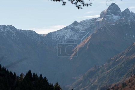 Téléchargez les photos : Une vue aérienne des montagnes escarpées rocheuses avec des arbres verts et des forêts sous un ciel nuageux bleu - en image libre de droit