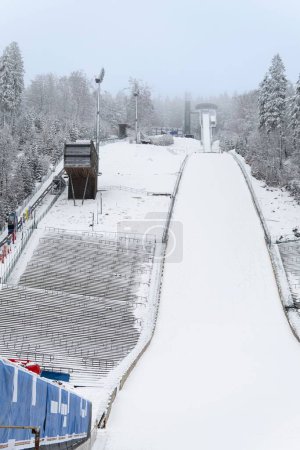Téléchargez les photos : Le saut à ski Muehlenkopf à Willingen, Allemagne. Les peuplements sont déserts. Les bâches pour les sponsors ont été retouchées. Plan vertical. - en image libre de droit