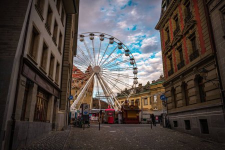 Téléchargez les photos : Une grande roue entourée de bâtiments à Lausanne - en image libre de droit
