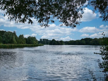 Téléchargez les photos : Un parc avec un lac où se trouve une fontaine par temps nuageux - en image libre de droit