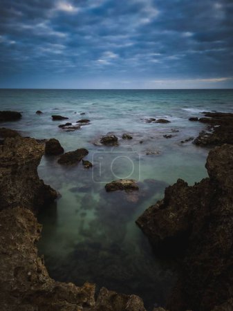 Photo for A vertical shot of the rocky coast of Albufeira, Sao Rafael, Portugal - Royalty Free Image