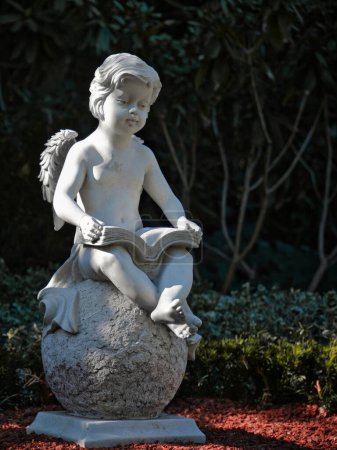 Téléchargez les photos : Un enfant ange de pierre lisant un livre sur une sphère - en image libre de droit