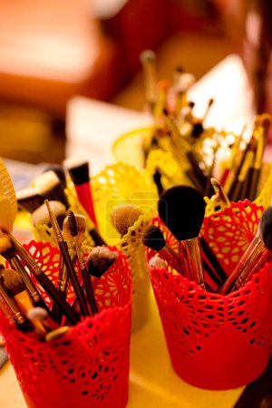 Photo for A vertical closeup shot of make-up brushes in a plastic container on the table, the concept of beautification - Royalty Free Image