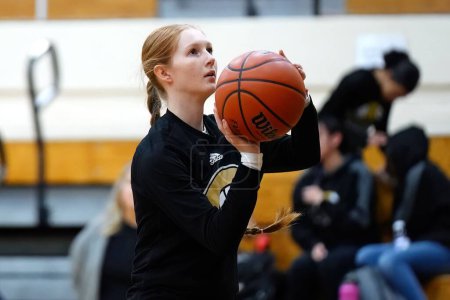 Téléchargez les photos : Une jeune joueuse sur un terrain intérieur à un match de basket-ball des filles du lycée - en image libre de droit