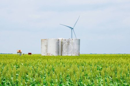Photo for A scenic shot of wind turbines and tank storages on a wheat field farm - Royalty Free Image