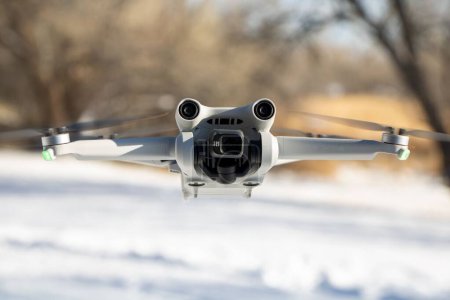 Foto de Una vista aérea de un avión no tripulado volando y grabando imágenes en un día soleado y nevado - Imagen libre de derechos