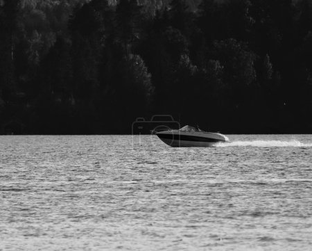 Foto de Una hermosa vista a escala de grises de un barco flotando en un lago - Imagen libre de derechos
