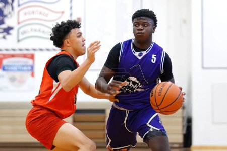 Foto de Un joven jugador de baloncesto negro en jersey azul regateando la pelota - Imagen libre de derechos